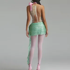 Detailed back view of a sexy backless sequin dress with a pink bow and green skirt.