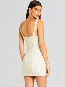 Gedetailleerd achteraanzicht van een witte met parels versierde bodycon-jurk