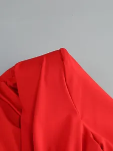 Detailed macro view of the vibrant red fabric and shoulder construction on a long sleeve dress