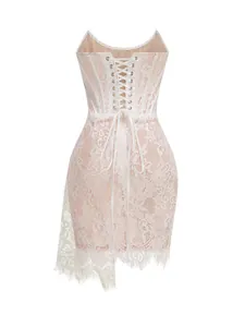 Detailed view of white lace corset dress with lace-up back and asymmetrical hem.
