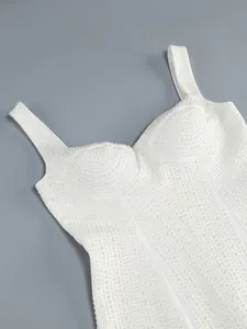 Gedetailleerde close-up van een witte avondjurk met verfijnde parelborduurdetails.
