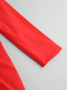 Macro view of the smooth red long sleeve cuff detail of this elegant evening dress