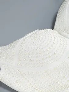 Detailopname van een elegante witte jurk met ingewikkelde handgeborduurde parels