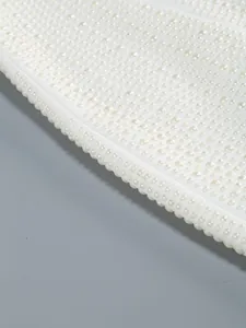 Macro-detail van een elegante witte jurk met ingewikkeld vakmanschap van parelkralen