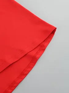 Detailed view of the red dress hemline with professional double-stitched finish.