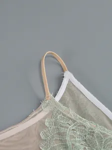 Detail view of pale green lace and nude mesh on an elegant evening dress strap