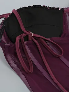 Close-up detail of purple sequined mesh dress showing straps and fine stitching.