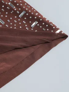 Primo piano di tessuto a rete marrone con strass luccicanti su un abito sexy e chic