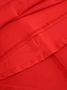 Close-up detail of the hemline and neat stitching on a vibrant red maxi dress.