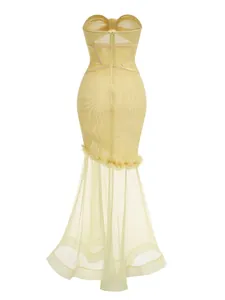 Detailed view of yellow strapless mesh mermaid dress with corset bodice and sheer hem
