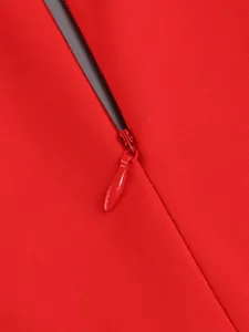 Close-up detail of the invisible zipper on an elegant red pleated long sleeve dress