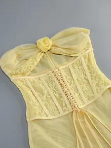 Detail view of a sexy yellow lace-up strapless dress with 3D flower and mesh patchwork