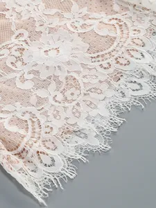 Detailed macro shot of elegant white floral lace fabric with delicate eyelash lace trim