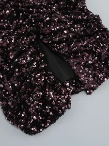 Close-up detail of dark purple sequins on a cocktail dress with a cutout design