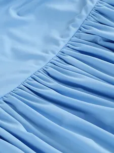 Close-up showing the intricate pleated ruffles on a light blue elegant vacation dress
