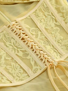 Close-up detail of yellow floral lace and mesh dress with corset lace-up design