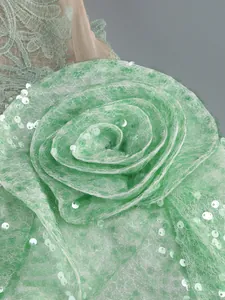 Close-up detail of mint green sequin 3D flower decoration on a party dress.