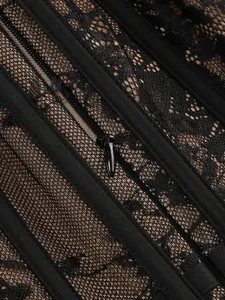 Close-up detail of black lace dress showing mesh texture and invisible zipper fastener