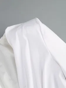 Detailed close-up of white ruched fabric from a high-end elegant long sleeve dress.