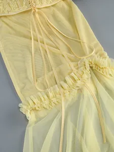 Detailed view of sexy yellow sheer mesh gown featuring lace-up back and floral lace