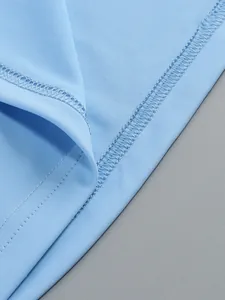 Close-up macro detail showing high-quality stitching on a light blue pleated dress fabric.