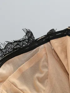 Close-up of black lace and nude mesh fabric with clear non-slip strap of an evening dress