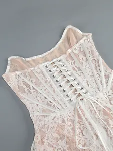 Close-up detail of white lace corset dress with elegant ribbon lacing on the back.