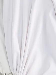 Close-up detail of white ruched fabric with crystal embellishments on elegant dress