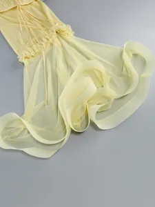 Close-up detail of yellow sheer mesh evening gown skirt with ruffled hem design