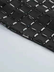 Vue macro d'une robe noire élégante ornée de strass géométriques brillants.