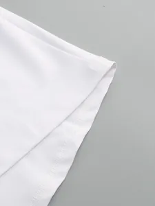 Close-up of the high-quality stitching and hem detail on a white long-sleeved dress fabric.