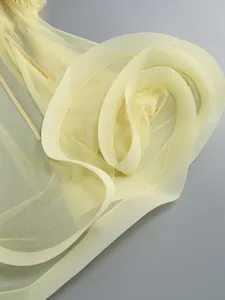 Close-up of yellow mesh dress detail with elegant floral ruffle and soft tulle texture