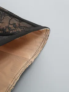 Detailed view showing the fine black floral lace and nude mesh lining of the dress
