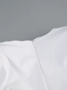 Close-up detail showing the high-quality invisible zipper on a white elegant evening dress