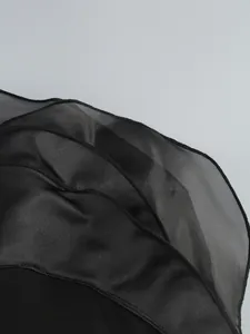 Close-up shot showing the delicate black sheer layered ruffles of an elegant evening dress.