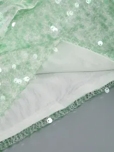 Close-up detail of light green sequined fabric with breathable mesh lining for banquet dress