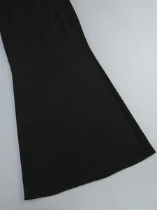 Detail view of the elegant black fabric hem on a long tight party dress