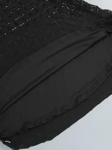 Vue détaillée des ornements en strass noirs sur tissu en maille pour robe de soirée.