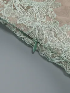 Close-up detail of mint green lace dress featuring delicate floral embroidery and invisible zipper
