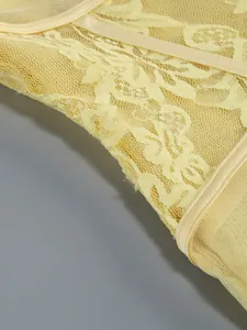Close-up of pale yellow floral lace and mesh detail on a sexy evening gown.