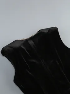 Détail d'une robe de soirée en velours noir avec une fine chaîne en strass et fermeture éclair