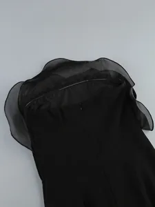 Close-up of the back hidden zipper and organza ruffle detail on a black strapless dress