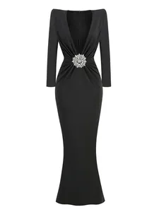 Detail of deep V-neck black evening gown with ruched waist and crystal floral brooch