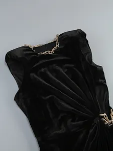 Gros plan d'une robe de soirée en velours noir avec détails de chaîne et découpe latérale
