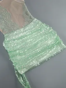 Detailed view of light green sequin party dress featuring delicate floral lace appliques