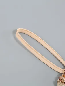 Close-up detail of beige shoulder strap and gold sequins on an elegant dress.