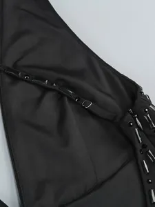 Gros plan détaillé des strass noirs et des boucles métalliques sur une robe élégante