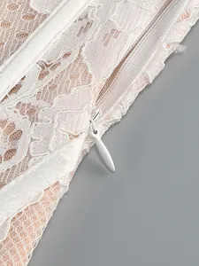 Detailed macro shot of an invisible zipper on a white floral lace evening dress