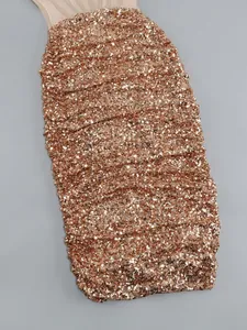 Close-up of rose gold sequins on a sexy ruched bodycon evening dress with mesh detail.