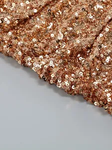 Macro view of high-density shimmering rose gold sequins on elegant mesh evening dress detail